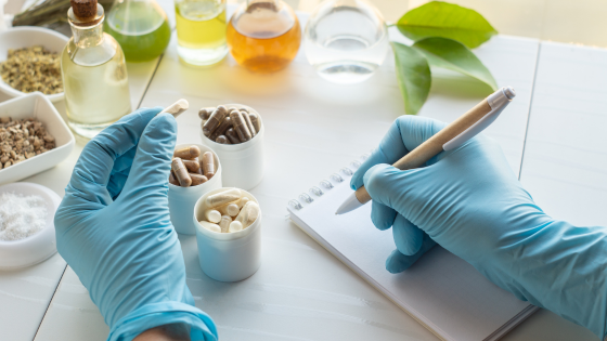Weight loss supplements inspected by a pharmacist writing on a notebook.